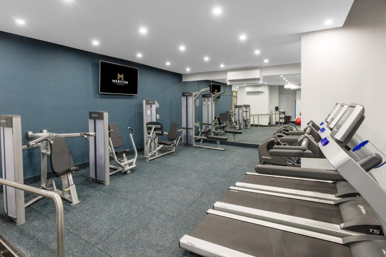 Meriton Suites Sussex Street, Sídney Exterior foto The photo shows a modern gym interior. The space features several pieces of exercise equipment, including weight machines and stationary bikes. The walls are painted a calming color, and the flooring is carpeted. There are also mirrors on the walls, 