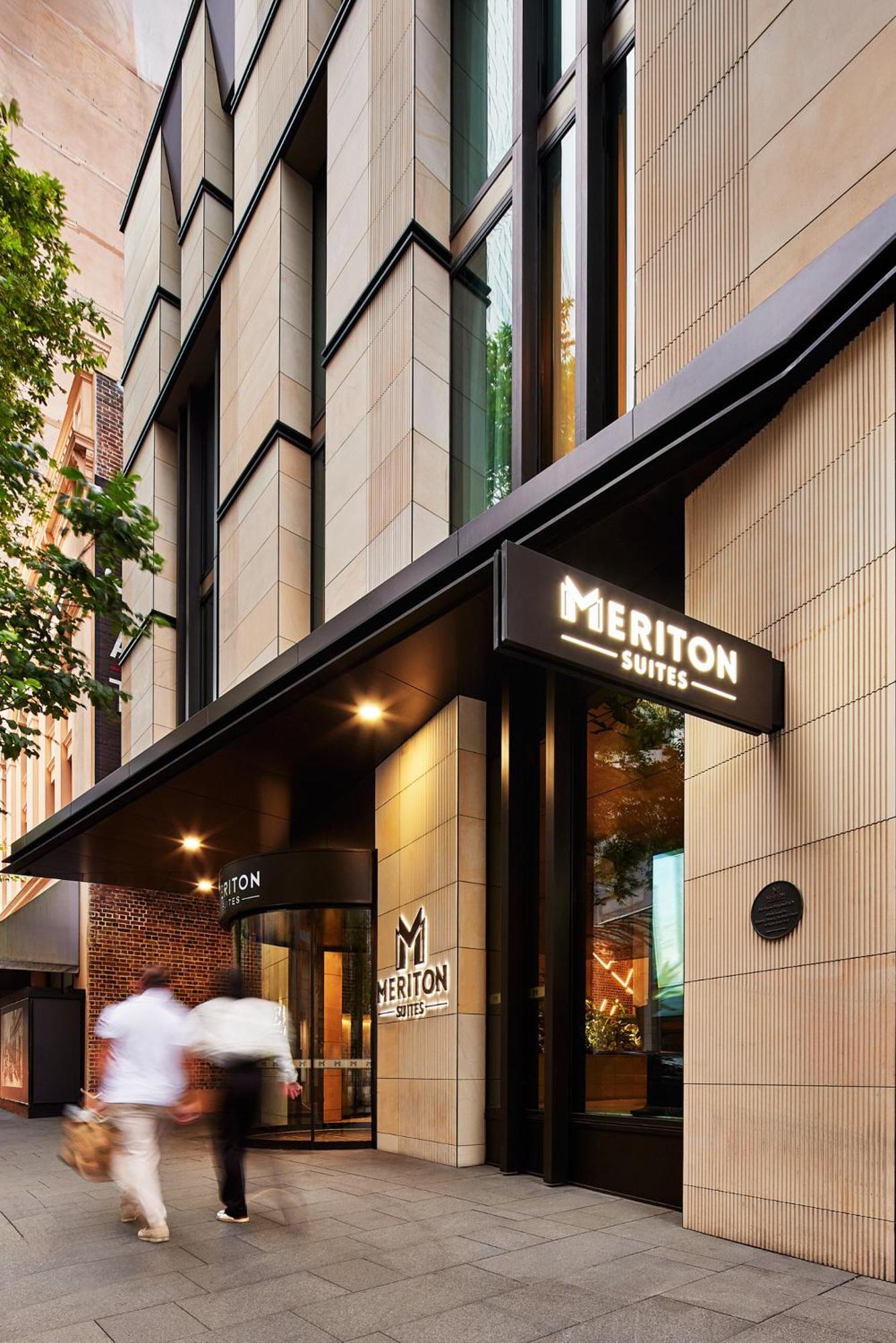Meriton Suites Sussex Street, Sídney Exterior foto The photo shows the exterior of a building with the signage for "Meriton Suites." The entrance features a modern design, with sleek architectural elements and large windows. The entrance is highlighted by a prominent awning and illuminated signs, ind